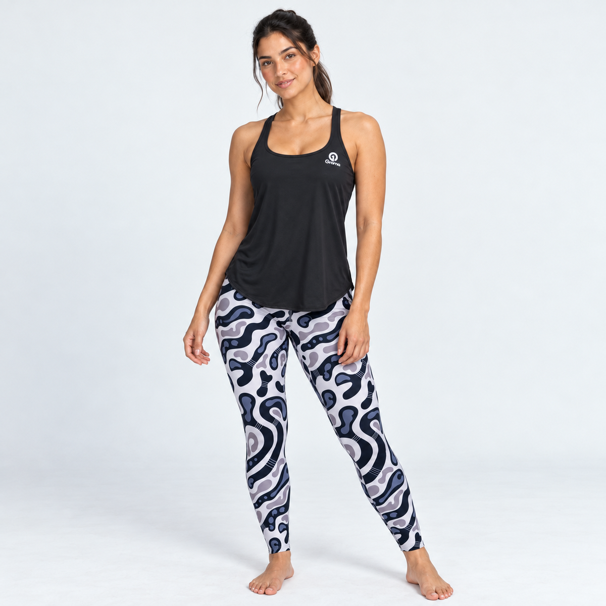 Modelo con Blusa Ivi negra y leggings deportivos estampados, look completo.