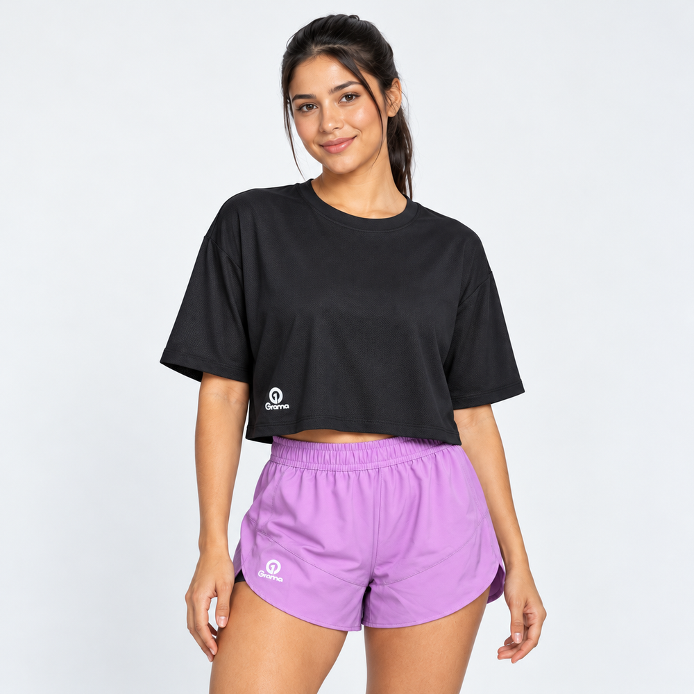 Modelo de frente con Blusa Over Crop 1 negra de Grama, manga corta, cuello redondo y logo frontal blanco