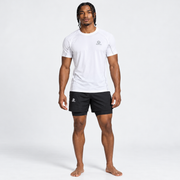 Modelo con camiseta Kaisen blanca de Grama y pantaloneta deportiva negra, vista de cuerpo completo