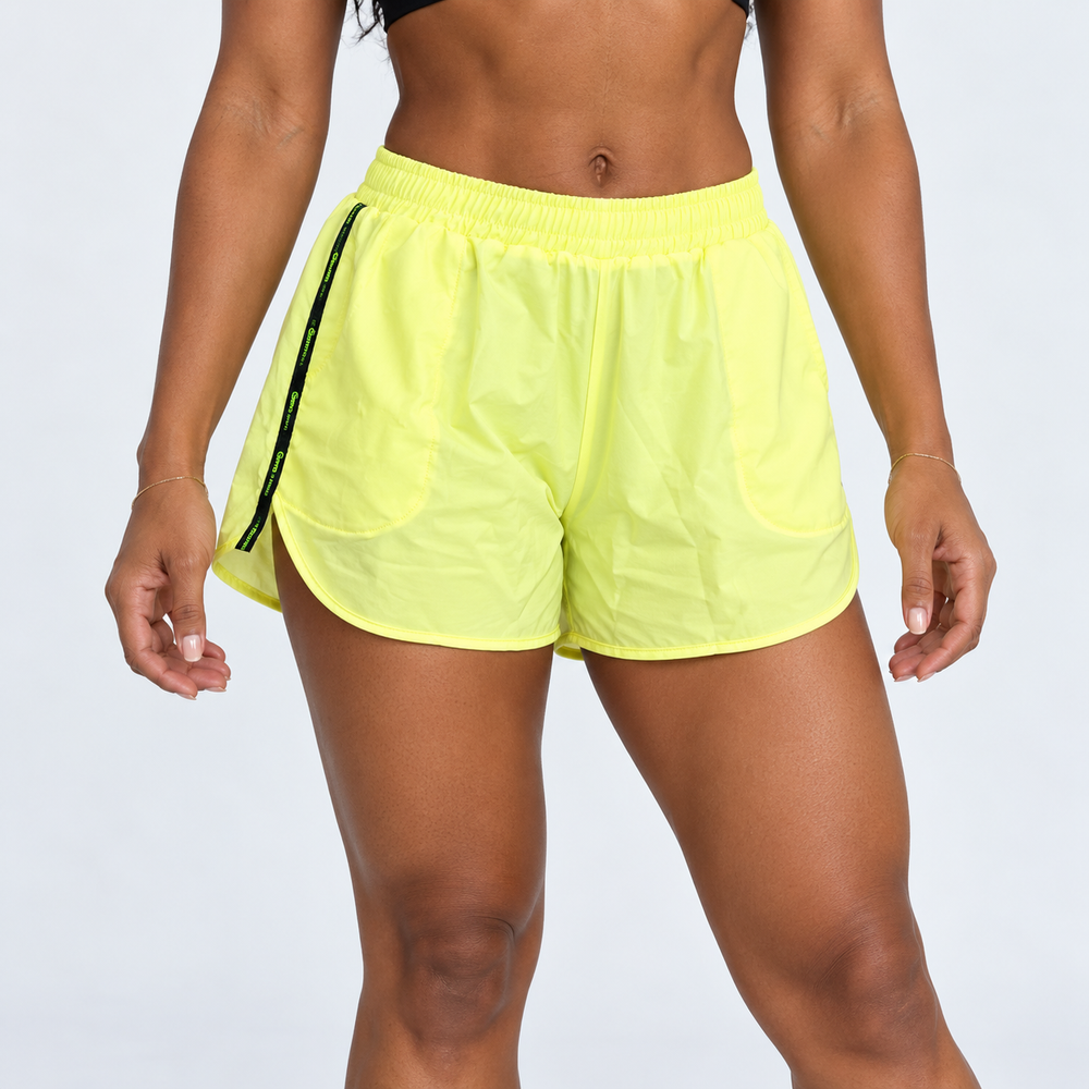 Pantaloneta deportiva Tabita amarillo neón para mujer, vista frontal con pretina elástica y detalles laterales