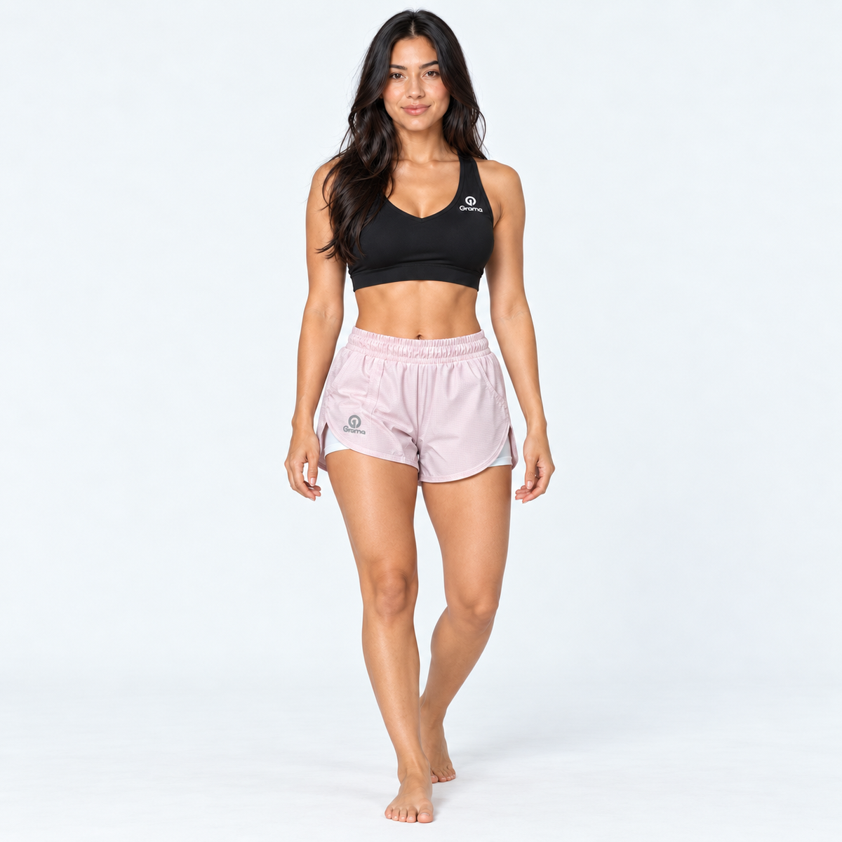 Modelo de cuerpo completo con pantaloneta Tabita II rosa claro y top deportivo negro