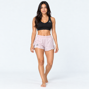 Modelo de cuerpo completo con pantaloneta Tabita II rosa claro y top deportivo negro
