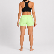 Short Lotus verde para mujer, vista posterior con pretina elástica y short interior blanco visible.